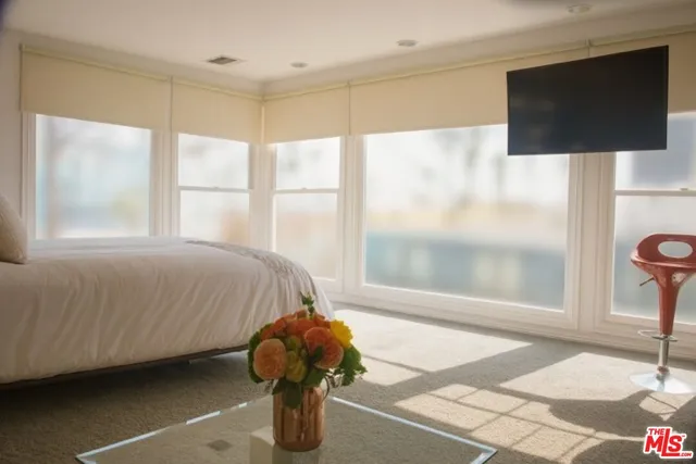 a bedroom with a bed and flat screen tv