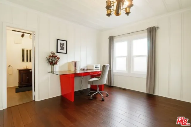a view of a workspace with wooden floor and a window