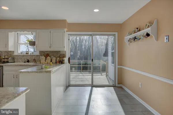 a view of an empty room with wooden floor and windows