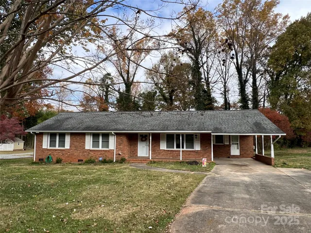 a view of a yard in front of a house with large tree
