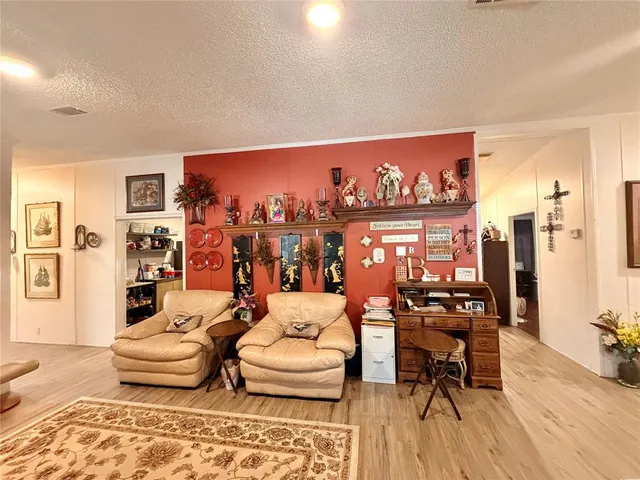 a living room with furniture and painting on the wall next to a window