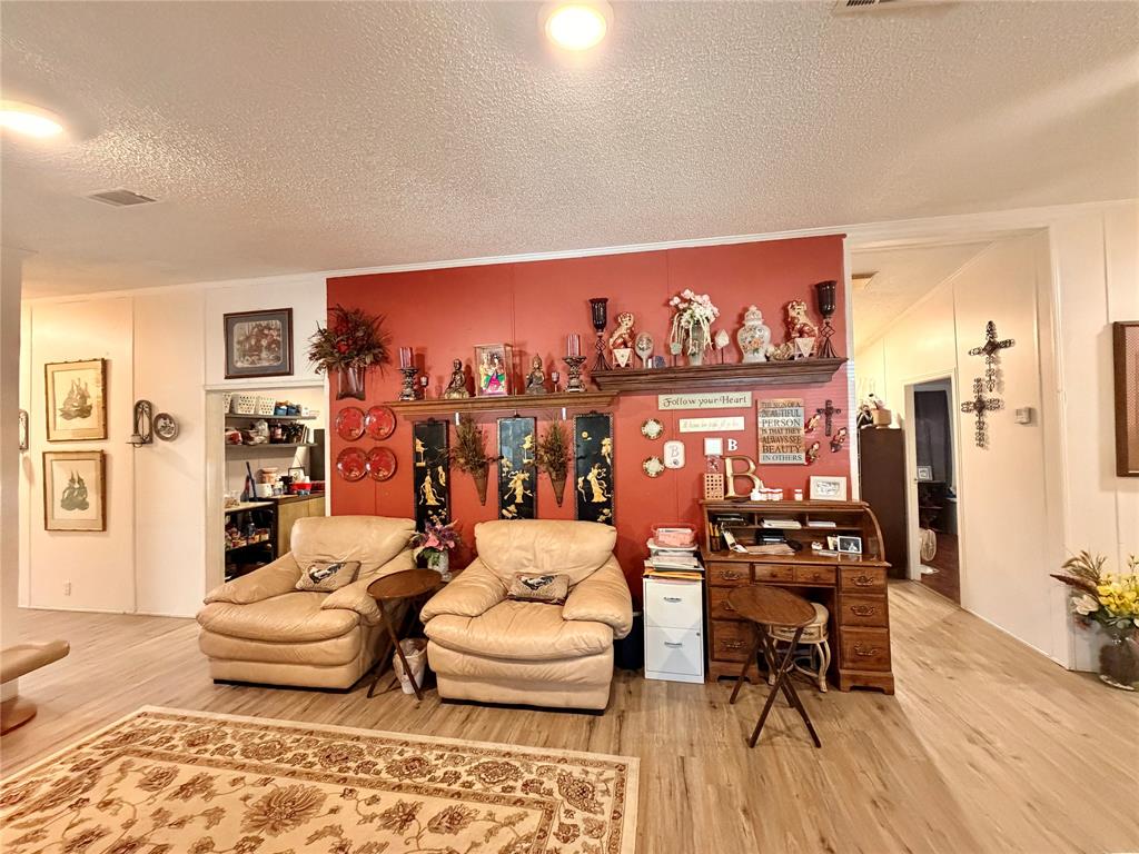 205 Hamilton Street Bynum, TX 76631 - Photo 16 of 29 a living room with furniture and painting on the wall next to a window