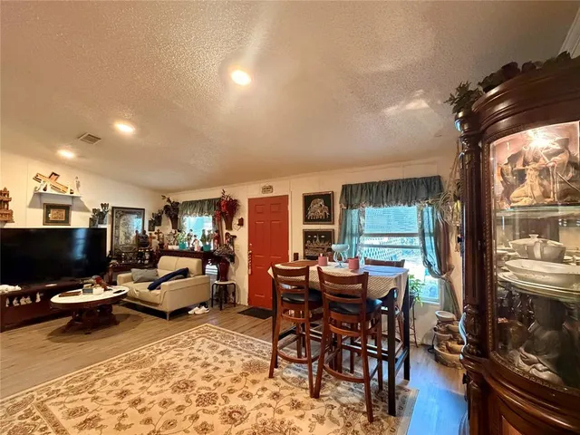 a living room with furniture a flat screen tv and floor to ceiling window