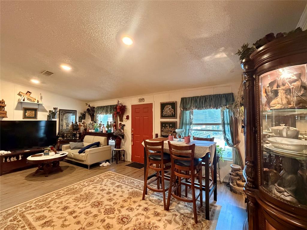 205 Hamilton Street Bynum, TX 76631 - Photo 17 of 29 a living room with furniture a flat screen tv and floor to ceiling window