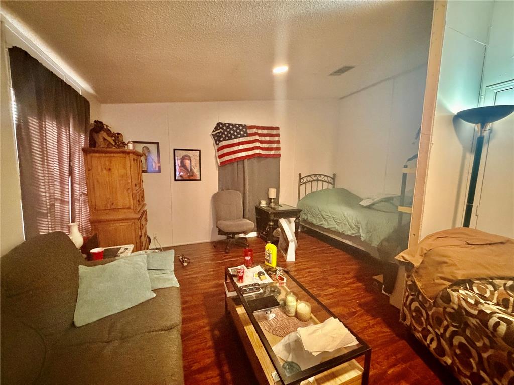 205 Hamilton Street Bynum, TX 76631 - Photo 23 of 29 a bedroom with furniture and a wooden floor