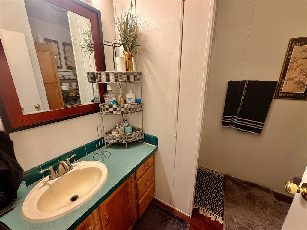 205 Hamilton Street Bynum, TX 76631 - Photo 24 of 29 a bathroom with a sink toilet and mirror