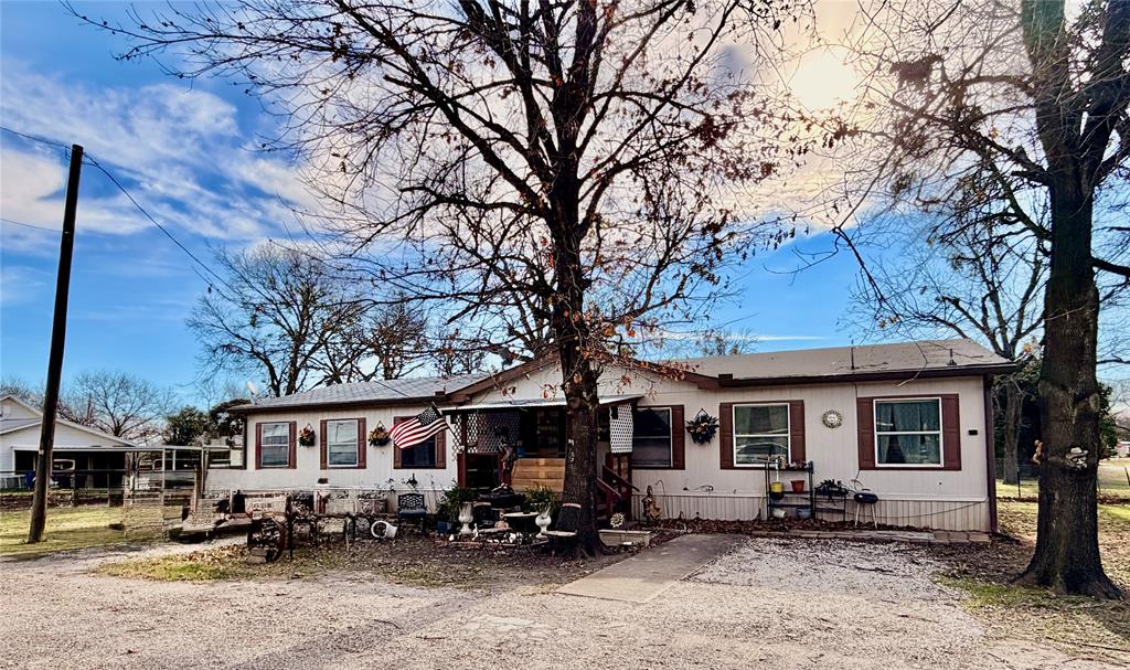 205 Hamilton Street Bynum, TX 76631 - Photo 3 of 29 a front view of a house with yard outdoor seating and covered with trees