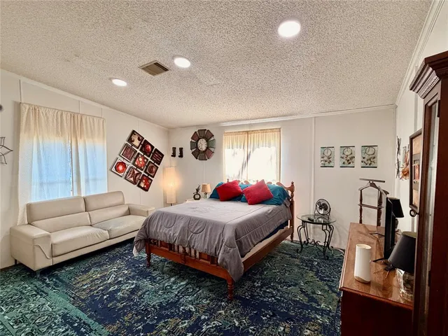 a bedroom with a bed couch and a window