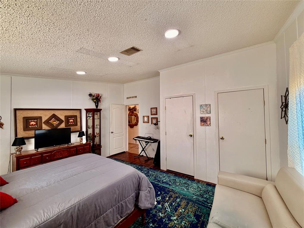 205 Hamilton Street Bynum, TX 76631 - Photo 5 of 29 a bedroom with a bed and a flat screen tv