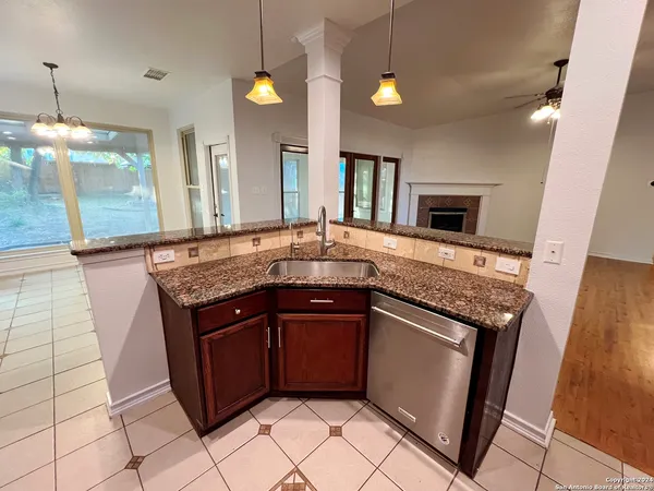 a kitchen with granite countertop a sink and a stove top oven