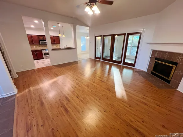 a view of a living room a dining room with wooden floor and a kitchen