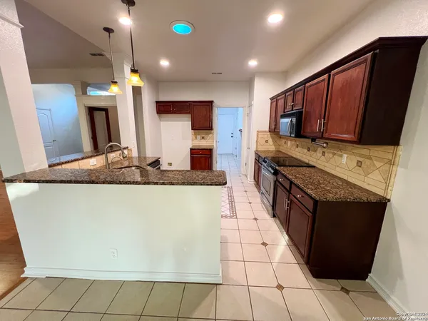 a kitchen with stainless steel appliances granite countertop a stove a sink and a refrigerator