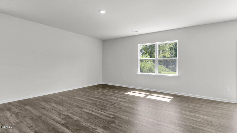 145 Westerly Way Lillington, NC 27546 - Photo 11 of 34 an empty room with wooden floor and windows