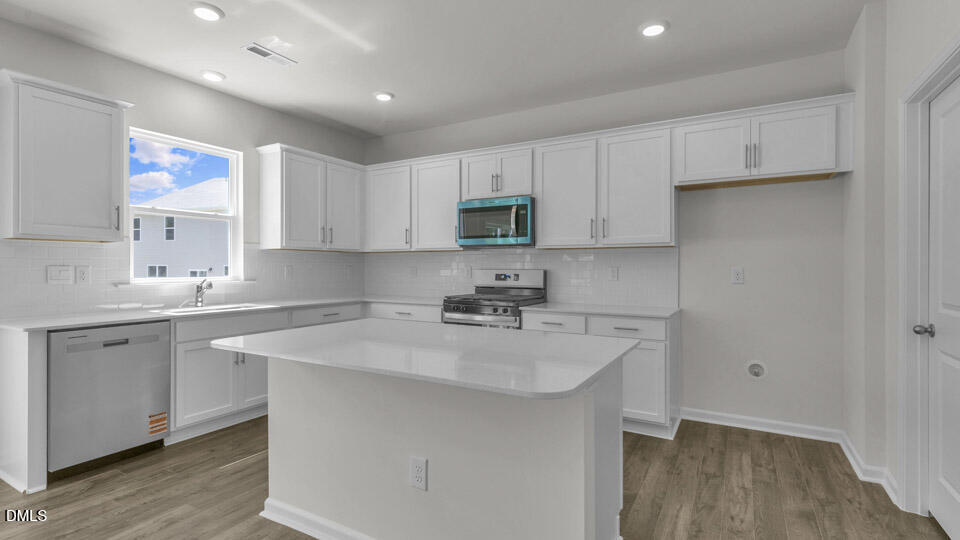 145 Westerly Way Lillington, NC 27546 - Photo 3 of 34 a kitchen with a sink cabinets and wooden floor