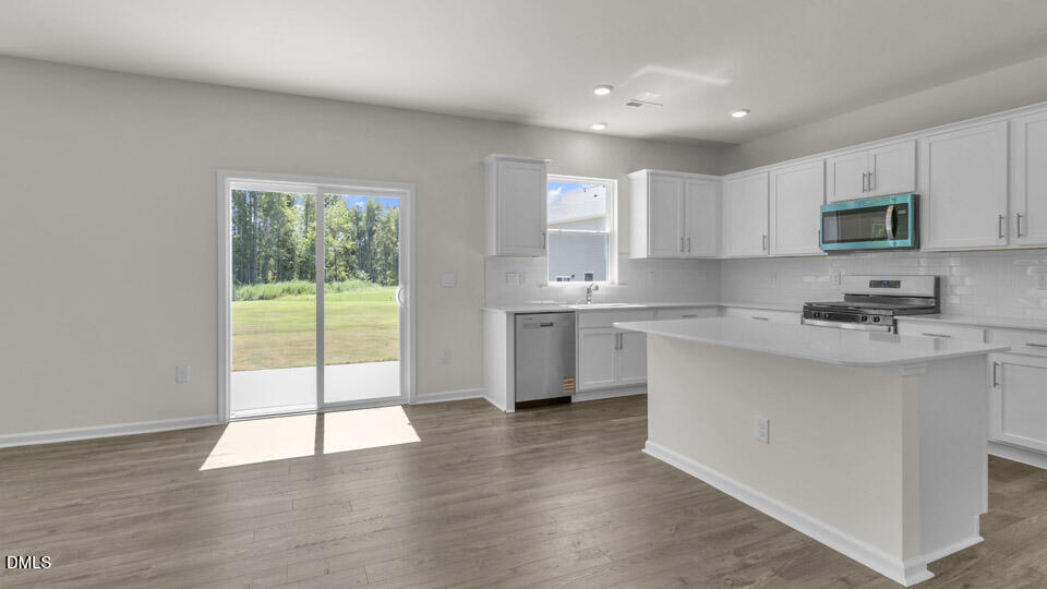145 Westerly Way Lillington, NC 27546 - Photo 7 of 34 a kitchen with stainless steel appliances granite countertop a stove a sink and a microwave