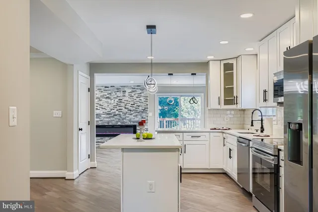 a kitchen with a sink cabinets stainless steel appliances and a window