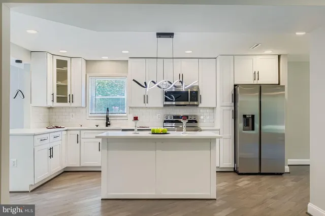 a kitchen with stainless steel appliances a sink stove refrigerator and cabinets