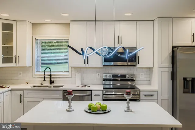 a kitchen with stainless steel appliances a sink a stove and a refrigerator