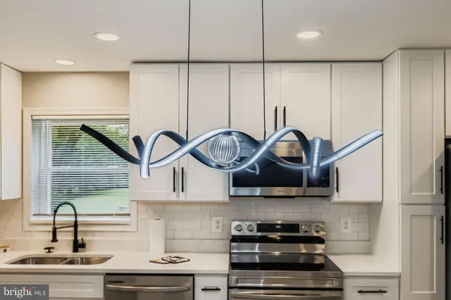 a kitchen with stainless steel appliances a sink a stove and cabinets