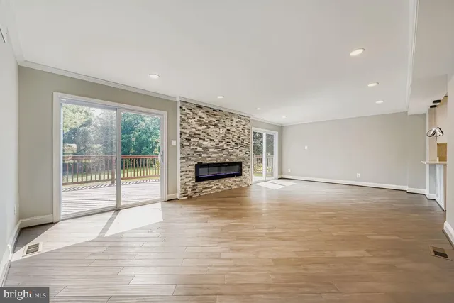 a view of empty room with wooden floor and fireplace