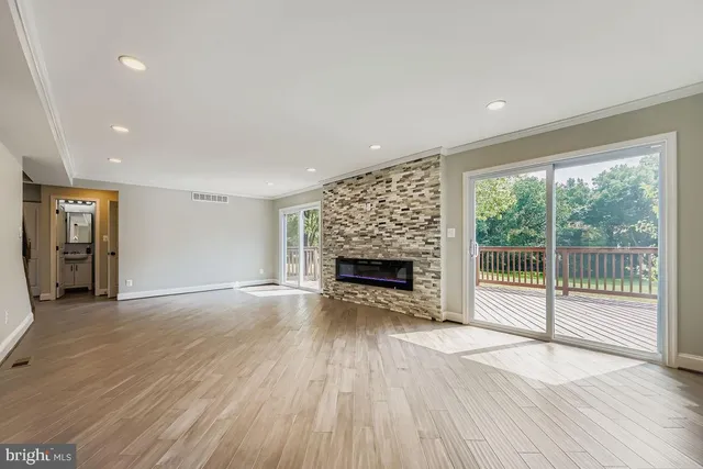 a view of empty room with wooden floor and fireplace