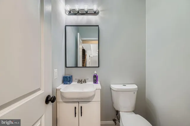 a bathroom with a toilet sink and mirror