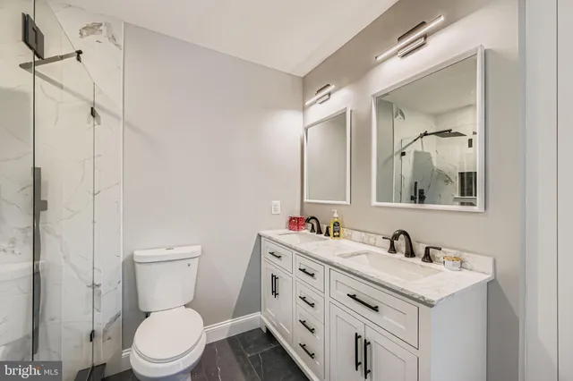 a bathroom with a sink vanity mirror and toilet