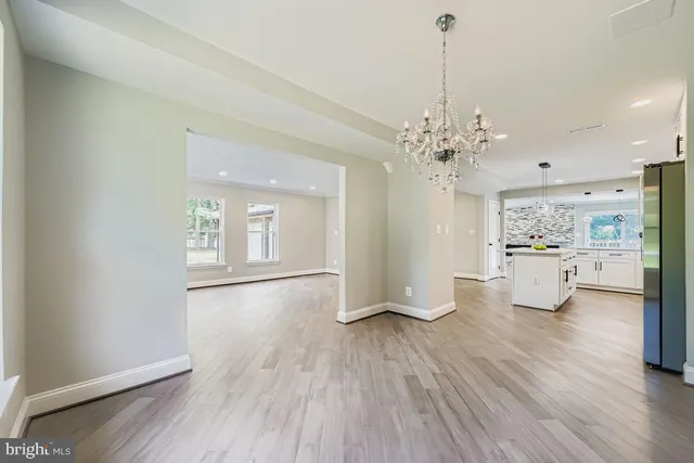 a room with chandelier and wooden floor