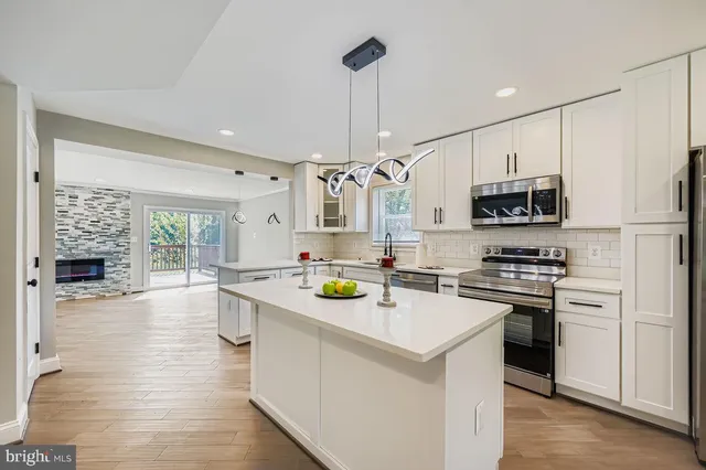 a kitchen with a sink a counter top space stainless steel appliances and cabinets