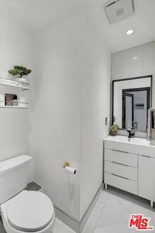 a bedroom with a large bed and wooden floor