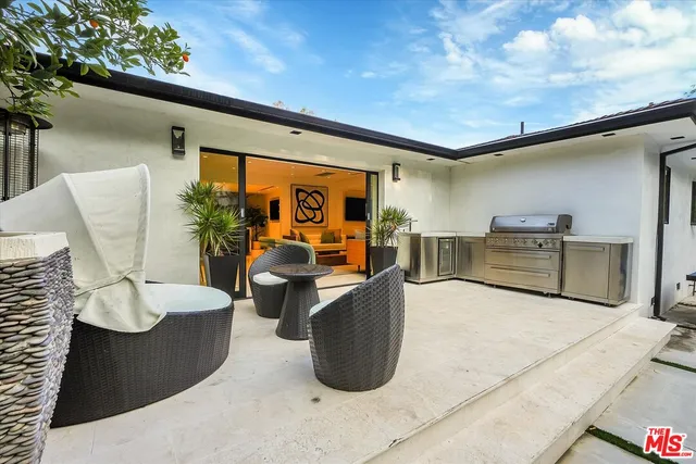 a view of a house with backyard and sitting area