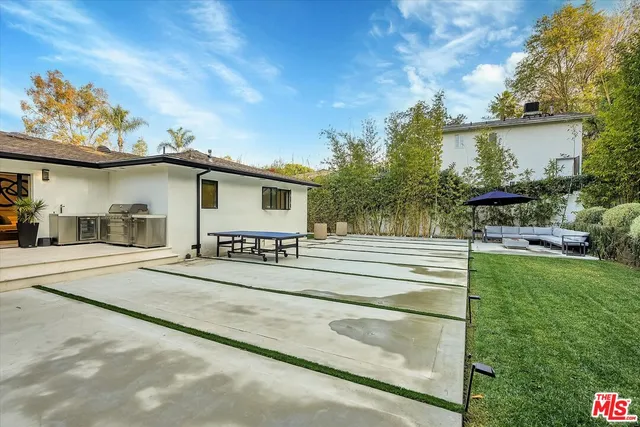 a view of patio with table and chairs under an umbrella