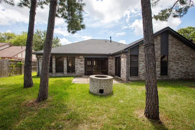 a backyard of a house with yard table and chairs