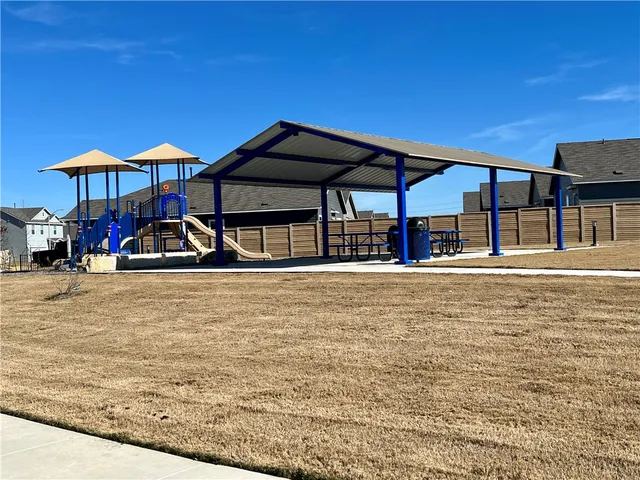 a front view of a house with large trees