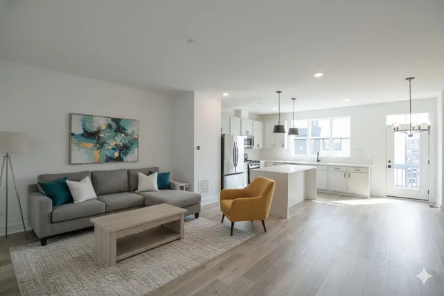 a living room with furniture and a dining table with kitchen view