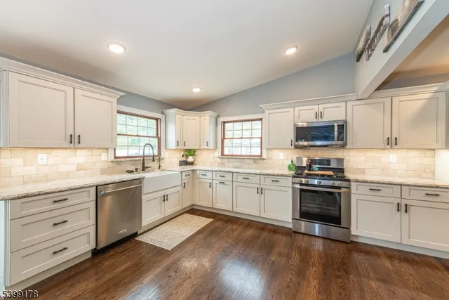 a large kitchen with cabinets wooden floor and stainless steel appliances