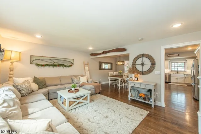 a living room with furniture a clock and a fireplace