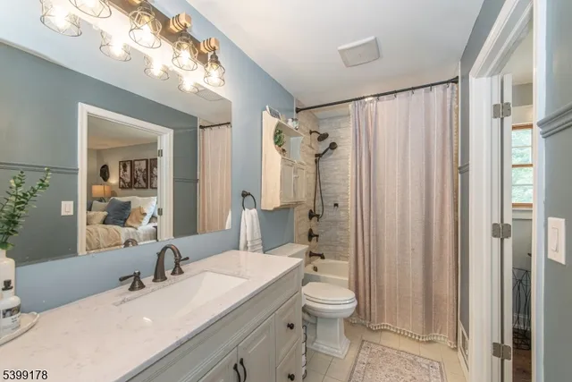 a bathroom with a sink a toilet a mirror a vanity and shower