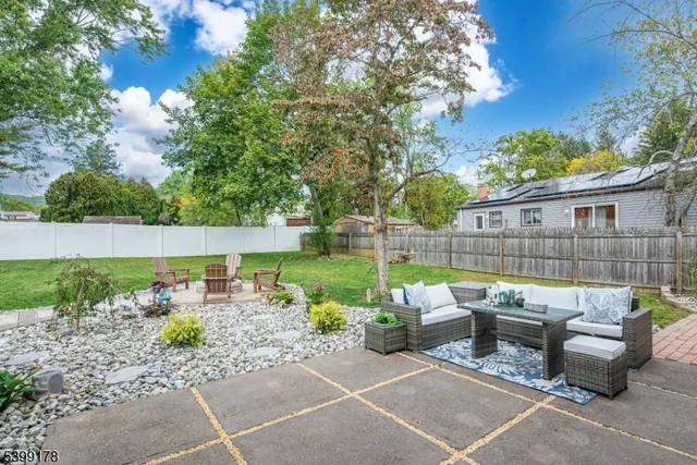 a view of backyard with table and chairs and wooden fence