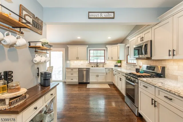 a large kitchen with stainless steel appliances granite countertop a stove and a sink