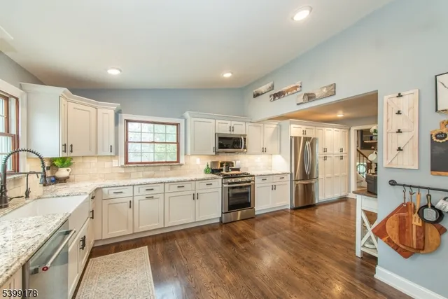 a large kitchen with granite countertop lots of counter top space and stainless steel appliances