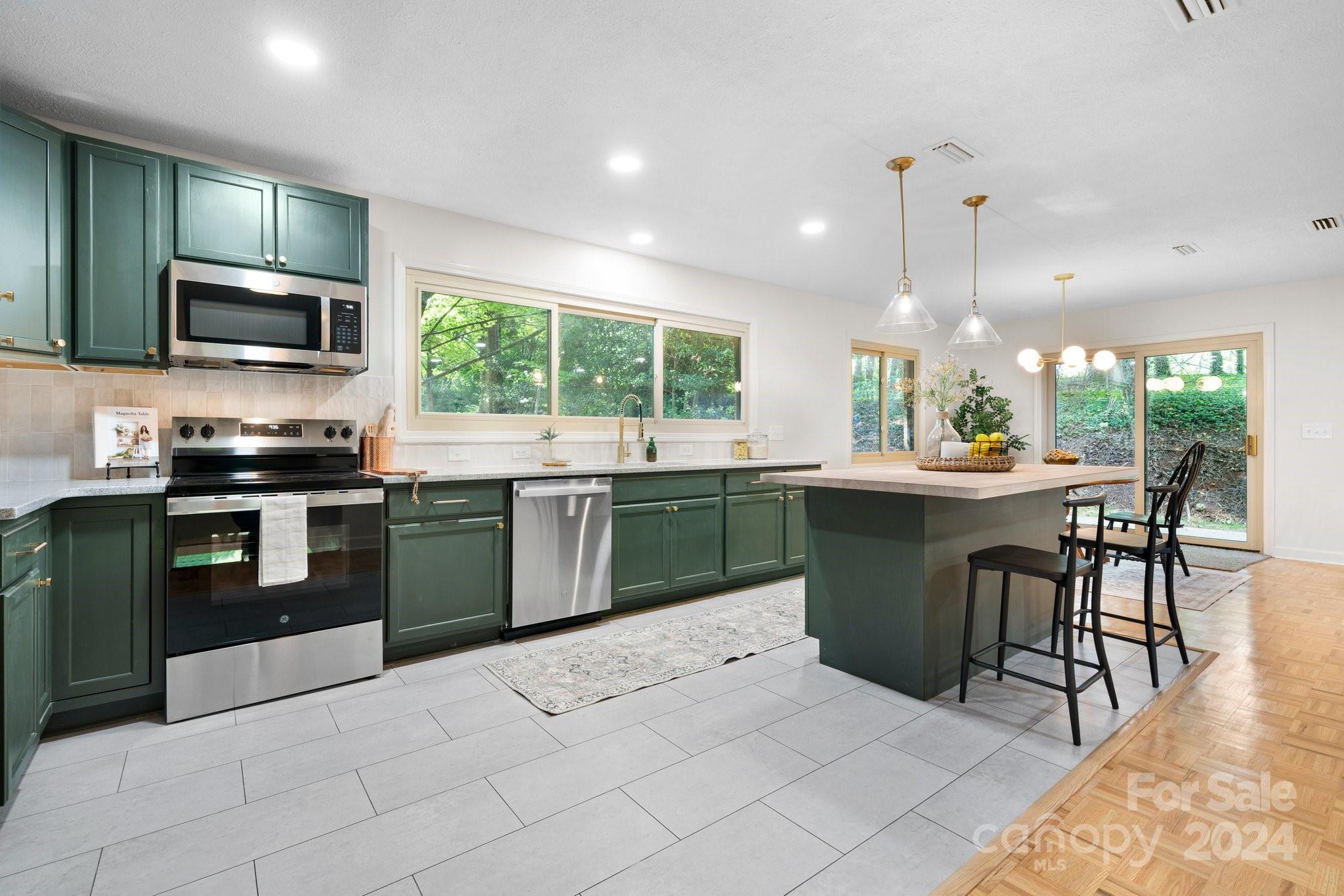 215 Blanton Road Morganton, NC 28655 - Photo 7 of 40 a kitchen with stainless steel appliances kitchen island granite countertop a sink counter space cabinets and a view of living room