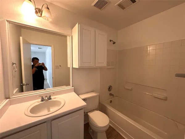 a bathroom with a granite countertop sink toilet a mirror and shower