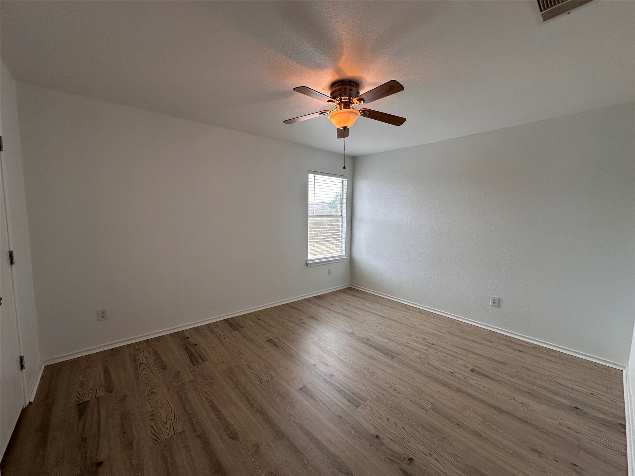 722 Lavaca Loop Elgin, TX 78621 - Photo 19 of 24 a view of an empty room with wooden floor and a window