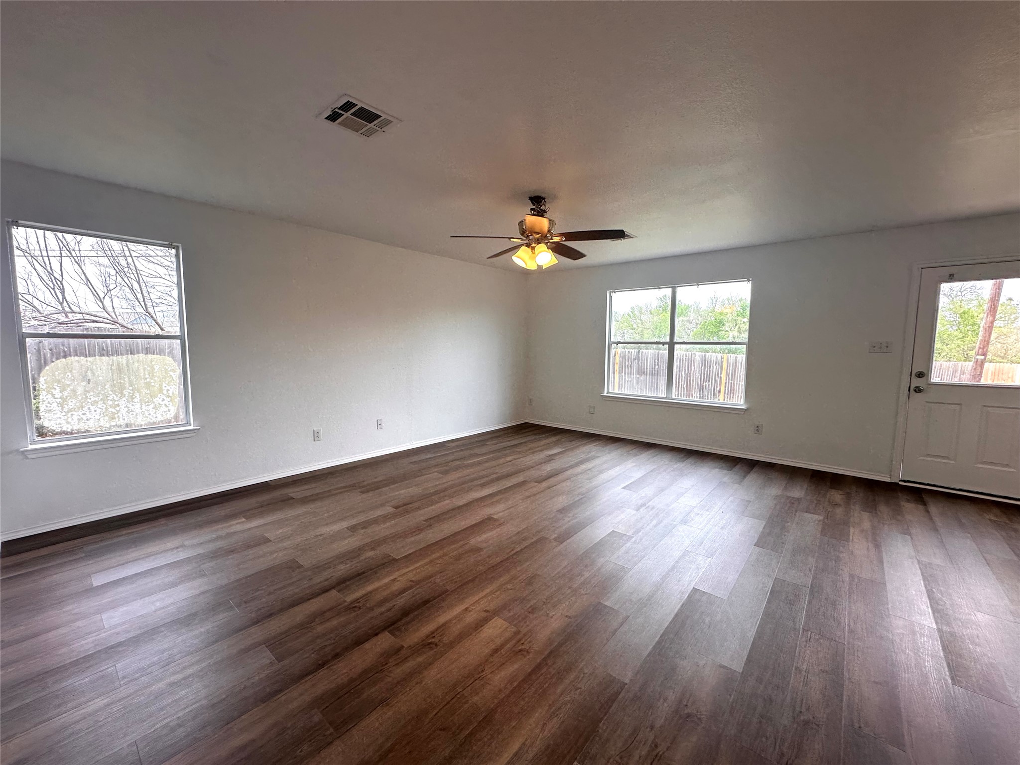 722 Lavaca Loop Elgin, TX 78621 - Photo 4 of 24 an empty room with wooden floor and windows