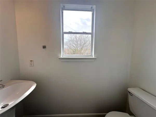 a bathroom with a toilet sink and window
