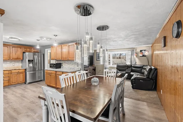 a large kitchen with a table chairs refrigerator and cabinets