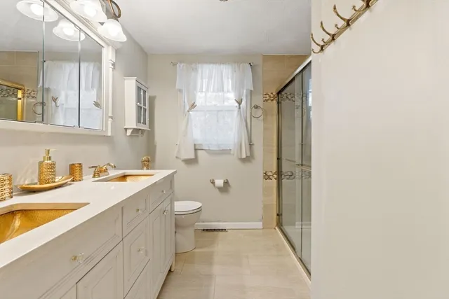 a bathroom with a granite countertop sink toilet and shower