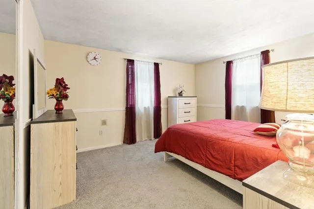 a bedroom with a bed and a refrigerator