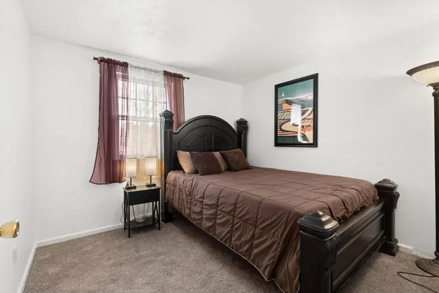 a bedroom with a bed chair and window